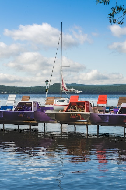 Yachts et catamarans sur la jetée au bord du lac. Beau temps calme.