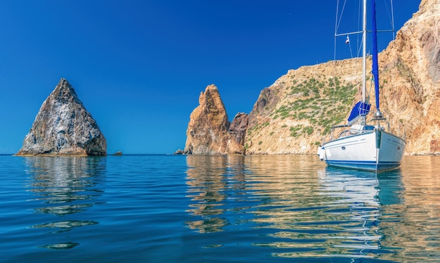 Yachts en mer sur fond de côtes rocheuses. Paysage de mer avec yachts et côte rocheuse. Copiez l'espace.