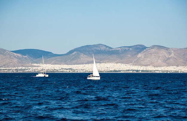 Yachts à voile dans la baie de la mer sur fond de montagnes au large de la Grèce