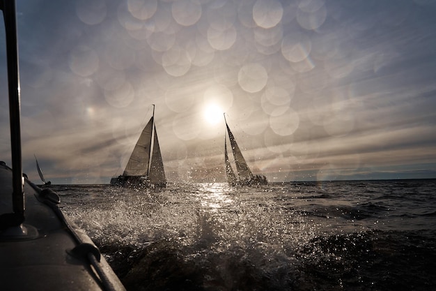 Yachts à voile en régate au coucher du soleil