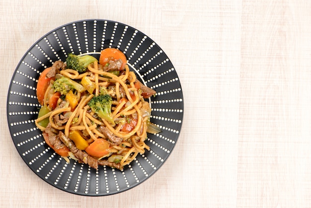 Yakisoba sur une plaque noire sur une table