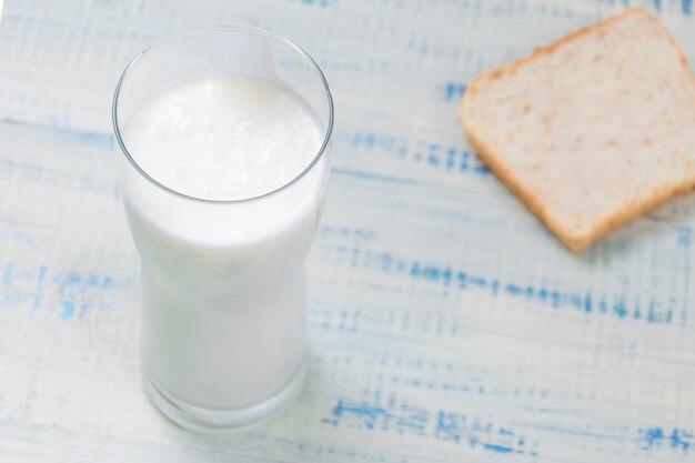 Yaourt au kéfir dans un verre sur fond de tranches de pain blanc sur fond de bois