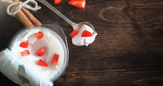 Yaourt frais aux fruits rouges. Crème glacée dans un bol avec des fraises et des cerises fraîches et juteuses. Dessert aux fruits rouges.