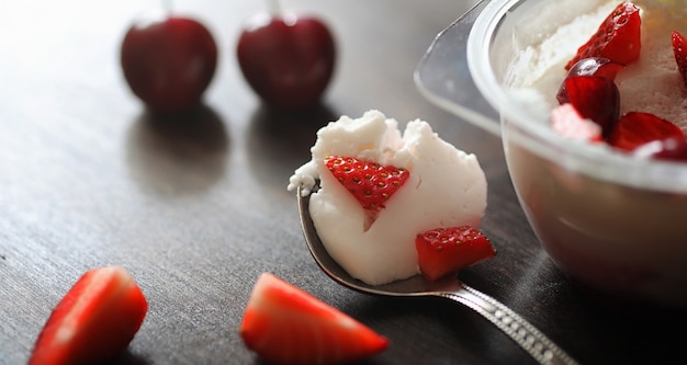 Yaourt frais aux fruits rouges. Crème glacée dans un bol avec des fraises et des cerises fraîches et juteuses. Dessert aux fruits rouges.