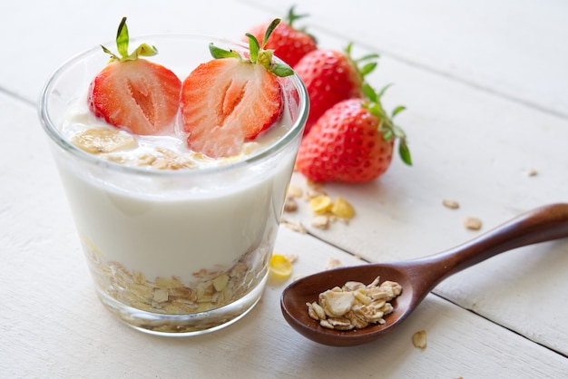 Yaourt Grec En Bonne Santé Avec Fraise Et Muesli Dans Le Verre Sur Une Vieille Table En Bois De Vue De Côté.