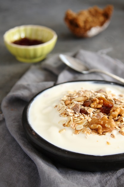 Yaourt naturel au muesli dans un vieux bol gris