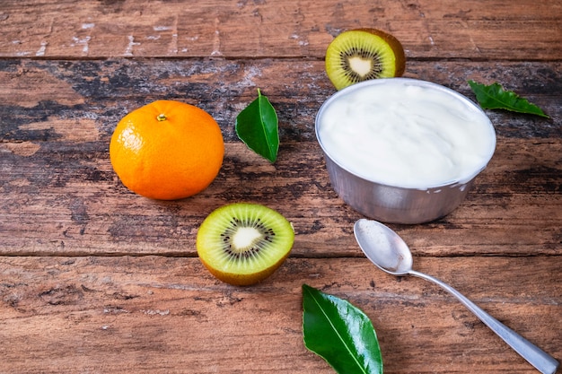 Yaourt naturel et fruits sur une table en bois