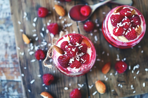 Yaourt à la noix de coco en pots avec framboises et confiture de framboises.