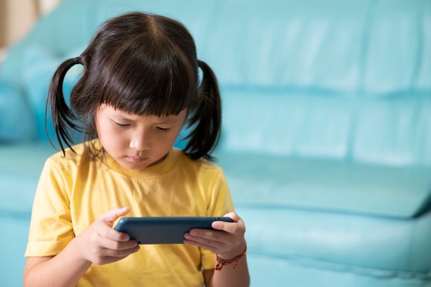 Yeux fatigués et fatigue due à l'utilisation prolongée du téléphone, enfant jouant à des jeux en ligne. Accro à Internet ou aux jeux en ligne