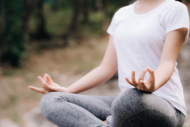 Yoga dans le parc. Fermer les mains de la femme faisant la méditation