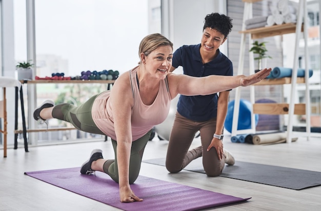 Le yoga fait tant de choses positives pour votre corps Photo pleine longueur d'une femme mûre faisant des exercices d'équilibre et de mouvement avec son physiothérapeute dans un centre de réadaptation