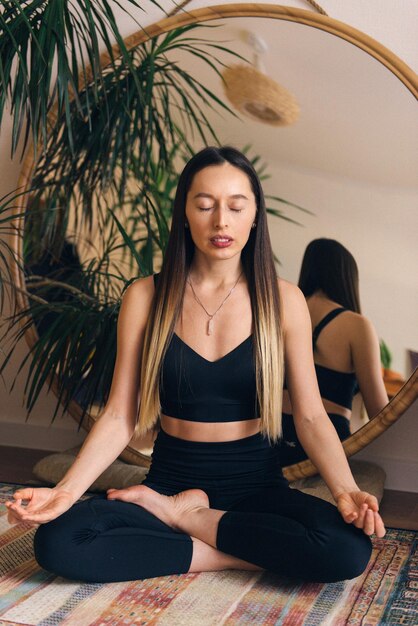 yoga femme assise sur le sol méditation pose les yeux fermés