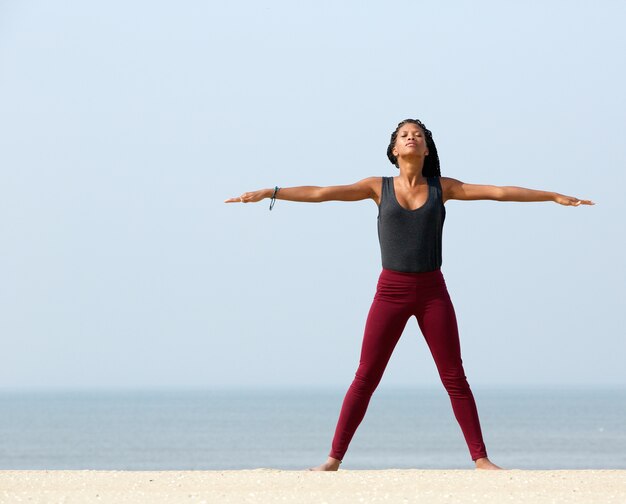 Yoga femme qui s&#39;étend à la plage