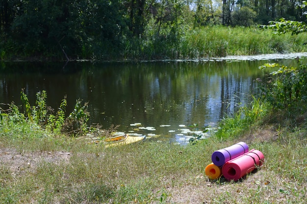 Yoga fitness ou tapis touristiques sur l'herbe verte à l'extérieur