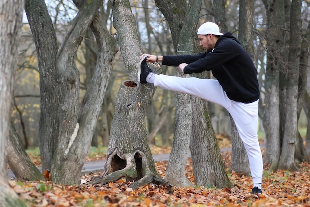 Yoga homme sport en automne parc s'asseoir sur un tapis