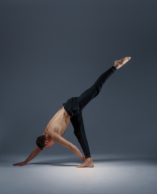 Yoga masculin garde l'équilibre sur les mains, position de méditation, mur gris Homme fort faisant de l'exercice yogi, formation asana, concentration maximale, mode de vie sain