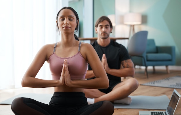 Yoga pour couples Photo recadrée d'un jeune couple athlétique méditant pendant son entraînement à la maison