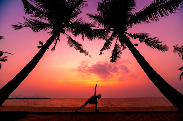 Yoga pratique belle jeune femme à la plage. Exercice tôt le matin. lever du soleil