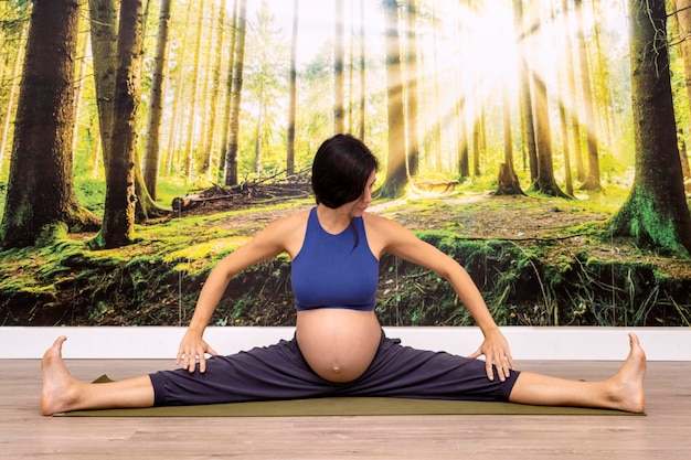 Yoga prénatal Instructeur de yoga enceinte et jambes ouvertes sur le sol