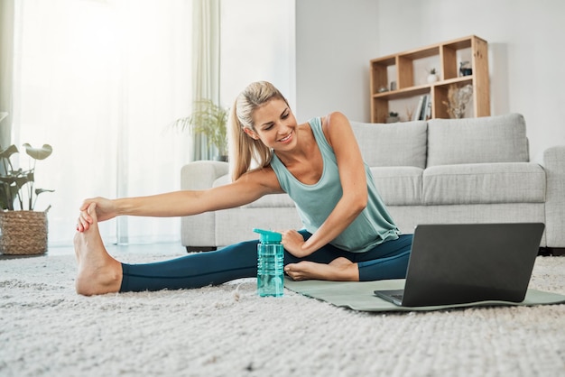 Yoga zen et femme qui s'étire sur un ordinateur portable en streaming vidéo de formation cours de yoga sur le Web ou tutoriel à la maison