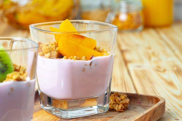 Yogourt aux baies avec granola et fruits dans un verre