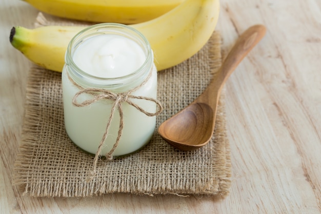 Yogourt en bouteilles de verre sur la table en bois