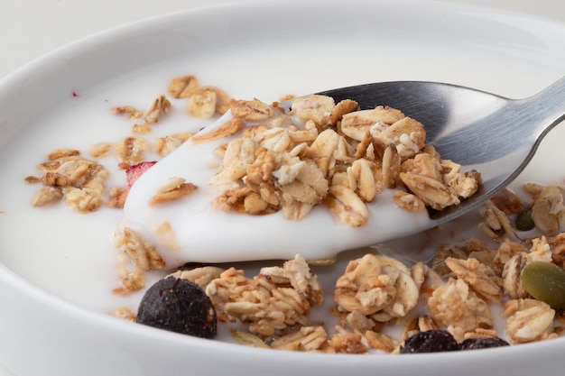 Yogourt avec granola sur cuillère en gros plan Mise au point sélective