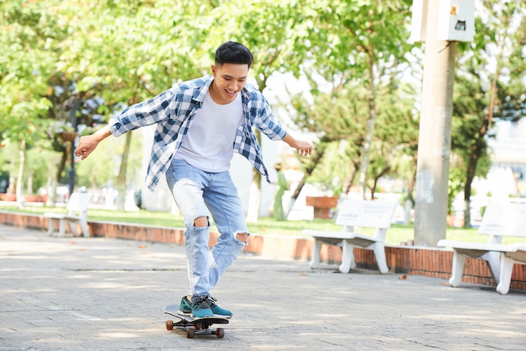 Photo yong homme branché s'amusant avec skateboard