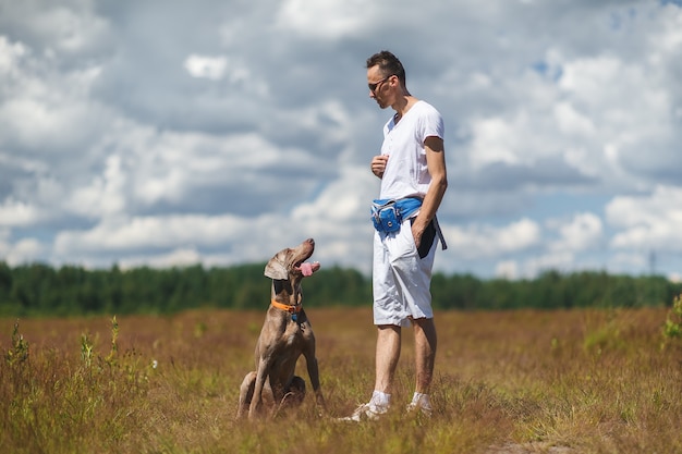 Yong man training gros chien au champ