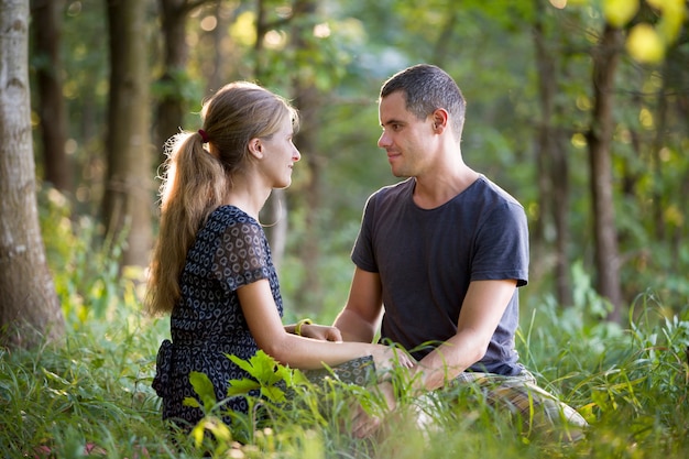 Youg couple homme et une femme assis ensemble à l'extérieur en profitant de la nature