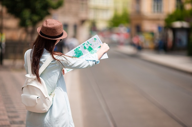 Youn girl avec le plan de la ville à pied dans les rues européennes. Voyage femme caucasienne avec carte à l'extérieur pendant les vacances en Europe.