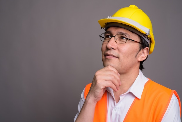 Young Asian man construction worker portant des lunettes contre g