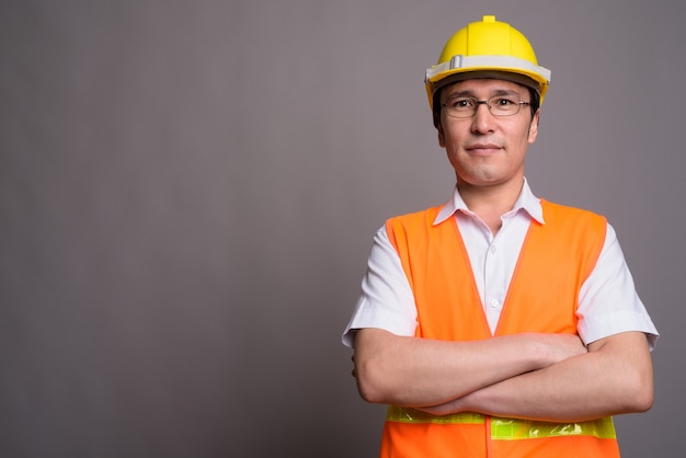 Young Asian man construction worker portant des lunettes contre g