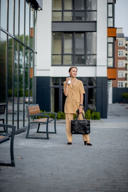 Young Businesswoman wearing Suit à l'aide de Smartphone dans un café en plein air