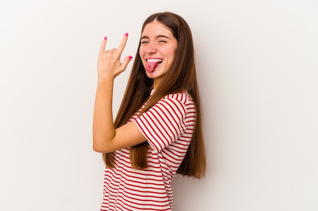 Young caucasian woman isolé sur fond blanc montrant rock geste avec les doigts