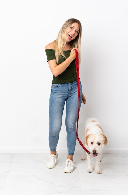 Young caucasian woman walking le chien isolé sur fond blanc célébrant une victoire