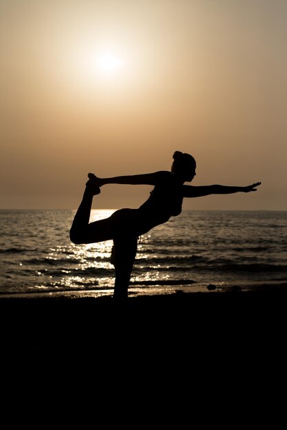 Young Healthy Woman Practicing Yoga Fitness Exercice sur la plage au coucher du soleil Mode de vie sain Concept Copier le texte de l'espace