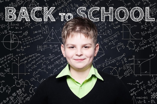 Young Student smiling on chalkboard Retour à l'arrière-plan de l'école