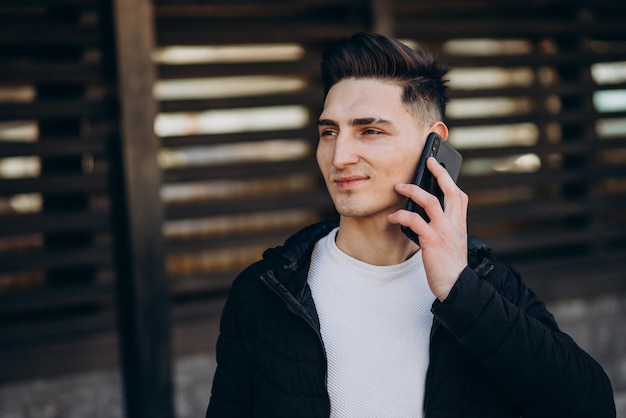 Ypoung homme parlant au téléphone dans la rue