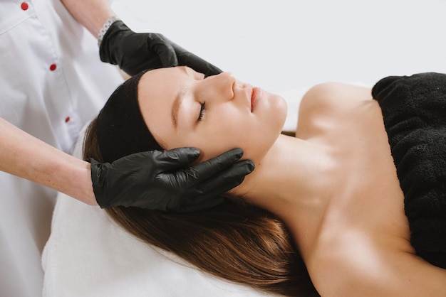 Ypung jolie femme relaxante dans un salon de beauté agrandi