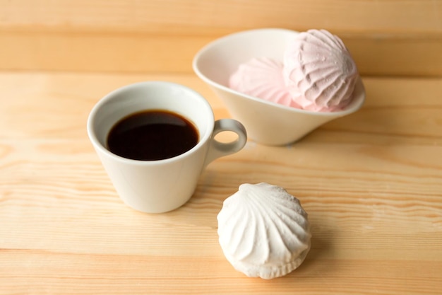 Photo zéphir blanc et tasse de café sur une table en bois