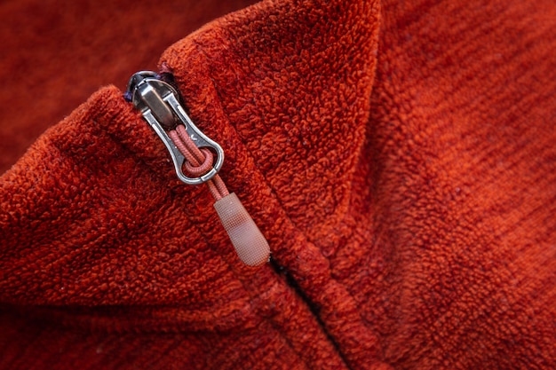 Zip zipper close up macro sur fond de vêtements rouges.