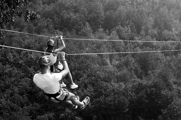 Zipline activité d'aventure passionnante Couple suspendu sur un téléphérique Touristes sur une tyrolienne à travers un canyon