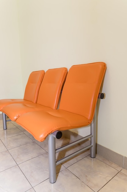 Zone d'attente du bâtiment public Détail de l'intérieur de l'hôpital Personne du hall de l'hôpital Chaises orange pour les patients attendant la visite du médecin Intérieur de la zone d'attente Sièges vides