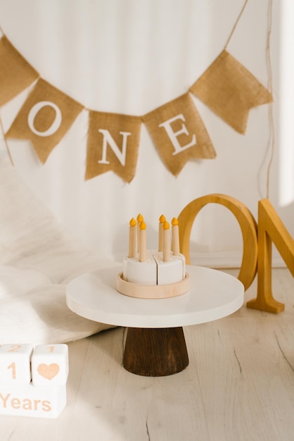 Zone photo pour un anniversaire ou un anniversaire avec un matelas des jouets en bois et un gâteau d'anniversaire