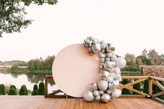 Zone photo rose ronde faite de ballons argentés avec un espace pour copier votre texte. Fête décorée de ballons