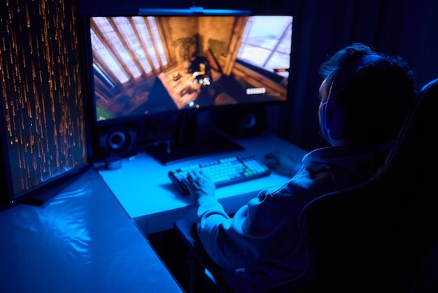 a coder is working late at night on a computer screen coding and using a smartphone app