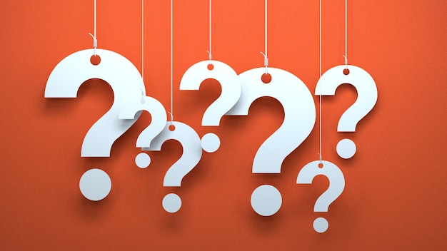 A group of question marks hanging from orange strings.