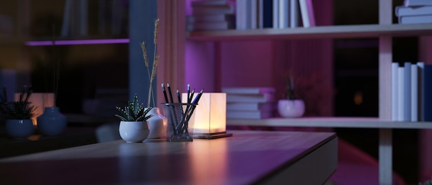 A hardwood desk in a modern dimly lit room at night with a table lamp on the table