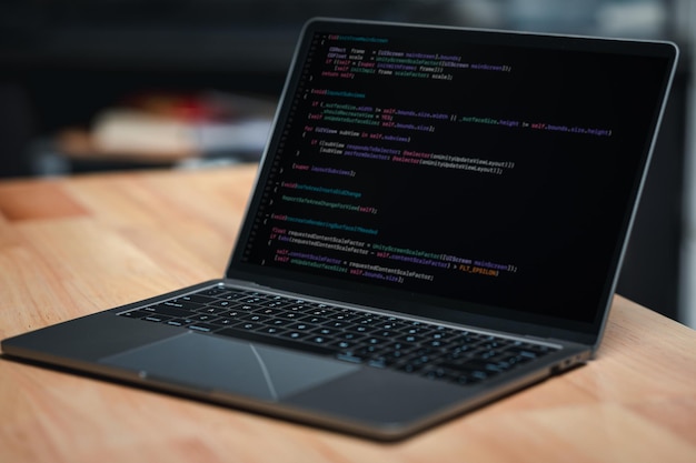 A laptop computer is open to a black screen with a lot of code on it